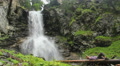 Male tourist having rest near mountain waterfall, wild nature Video