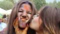 Girl kissing friend on cheek, faces covered in colorful paint Video