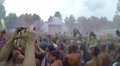 Colorful powder paint above people's heads at concert, slow-mo, click for HD Video