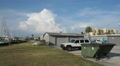 Garage Building Next To Dumpster In Parking Lot With Clouds HD Video