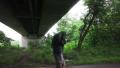 Man Walks Under Bride In Forest With Jacket Over Head To Protect From Rain HD Video