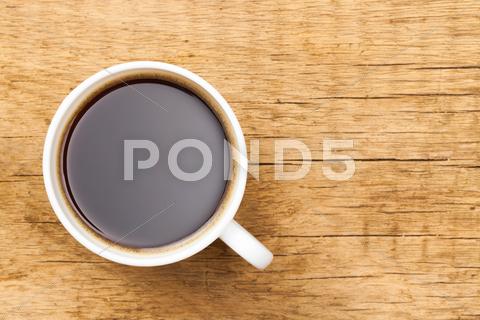 Black Coffee In White Ceramic Cup On Wooden Table - View From Top
