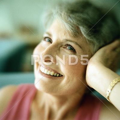 Portrait Of Mature Woman Smiling With Head Resting In Hand