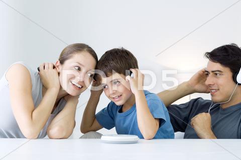 Family Listening To Cd Player Together, Mother And Son Sharing Headphones