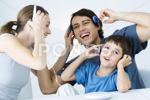 Family Listening To Cd Player Together, Father And Son Using Wireless Headphones