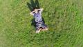 Happy man lying on grass hands behind head, aerial shot Video