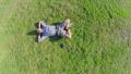 Aerial, young positive man lying on ground hands behind head Video