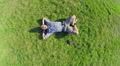 Aerial vertical shot of happy male lying on grass, zoom-out Video