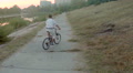 Man riding bicycle in park alley near river, aerial shot Video
