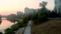 Young man cycling in park, panoramic view of city, aerial Video