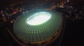 Flying over football stadium at night, city lights, panorama Video