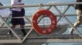 People Walk Off Passenger Ferry Walkway From Boat Dock With Life Preserver HD Video