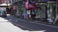 Car Traffic Drives By Shops And Cafe On Japanese Street HD Video