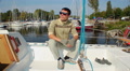 Handsome confident male in glasses sitting on luxury yacht Video