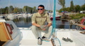 Portrait of positive young man on sailboat in marina, yachting Video