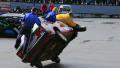 Stunt performers change tire while driving car on two wheels Video