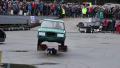 Petite stunt woman dives under fast-driving car, auto show Video