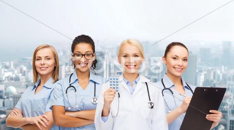 Smiling Female Doctor And Nurses With Stethoscope