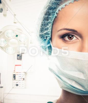 Young Woman Doctor In Cap And Face Mask In Surgery Room Interior