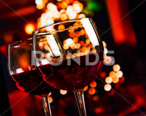 Two Red Wine Glass Against Christmas Lights Decoration Background