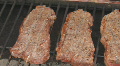 Steaks cooking on charcoal grill pan left to right Footage
