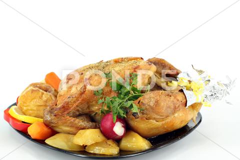 Stock photo of roasted whole chicken with vegetables