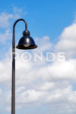 Stock photo of a single hooded street light with blue sky background