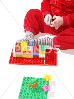 Stock photo of unrecognizable kid in red, playing