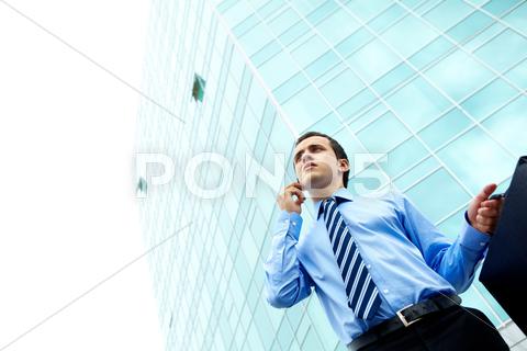 Stock photo of businessman standing by office building