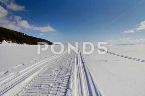 Stock photo of snowmobile trail stretching into the distance
