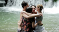 girls of boys have fun in a waterfall. hugging and playing with water Video