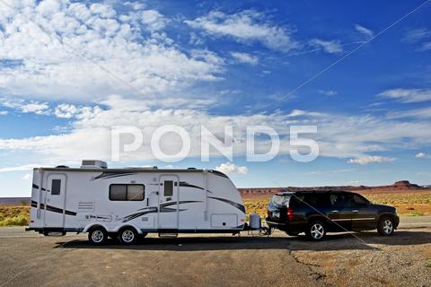 Stock photo of rv trailer journey. travel trailer pulling by SUV