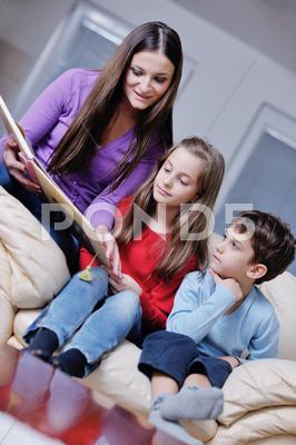 Stock photo of young mom play with their kids at home and reading book