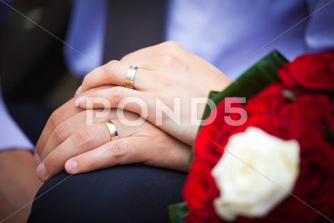 Stock photo of bride and groom holding hands