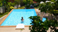 Woman Swimming in Blue Outdoor Swimming Pool. Beautiful Summer Landscape. Video