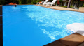 Man Swims Back in Private Outdoor Swimming Pool near Luxury Villa. Video