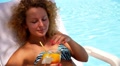 Woman in Bikini on Chaise Longue Drinking Fresh Juice by the Pool. Video