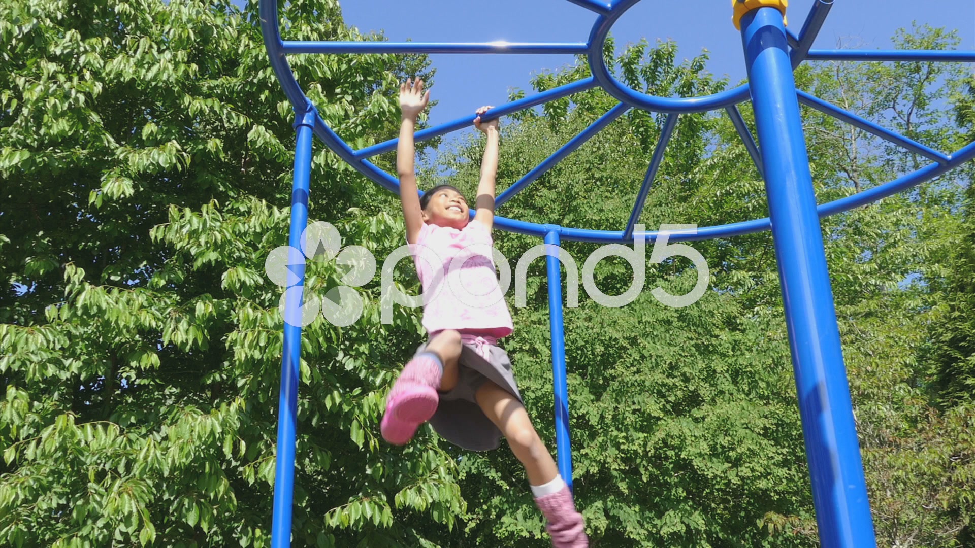 Brave Little Girl Tackling The Monkey Bars At Playground.