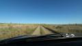 Driving on rough rural dirt road between two fields. Saskatchewan, Canada. Footage