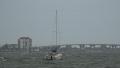 Sail Boat Bobbing In Waves And Wind On Stormy Day Bridge In Background Footage